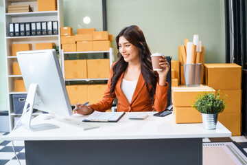 A young Asian businesswoman sits at her table, watching the computer screen.She analyzes, plans,...
