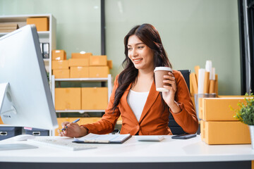 A young Asian businesswoman sits at her table, watching the computer screen.She analyzes, plans,...