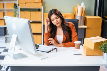 A businesswoman sits at the table, stressed as she works to sell products online. Sales are poor, losses mount, the market is quiet, customers disappear, and targets are not reached.