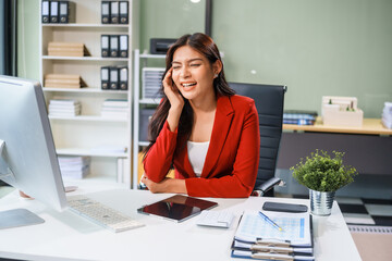 An Asian businesswoman sits at the table, working long hours as a financial analyst on computers  tablets.experiences office syndrome symptoms like neck pain, headaches, stress,other health issues.
