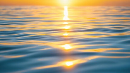 Fototapeta premium Golden sunlight reflects on calm ocean water at sunrise.