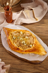 Delicious Khachapuri Filled with Dor Blue Cheese and Nuts on Wooden Table