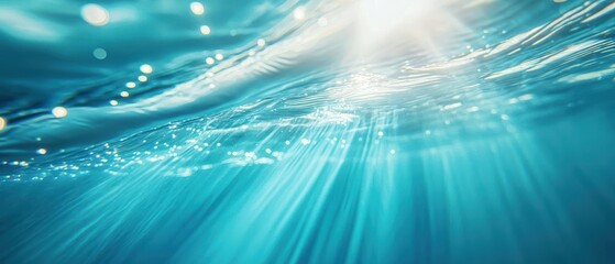 Sunlight rays penetrate the surface of clear blue water.