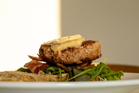 An open-faced home-made bacon cheeseburger with salad.