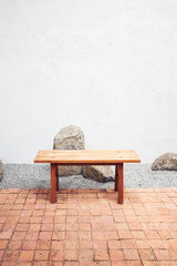 Wooden bench with plain white wall background