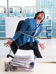 Chained male employee unhappy with excessive work