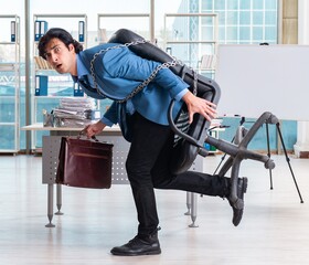 Chained male employee unhappy with excessive work