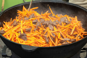 Wok pan with carrots and meat, cooking street fast food