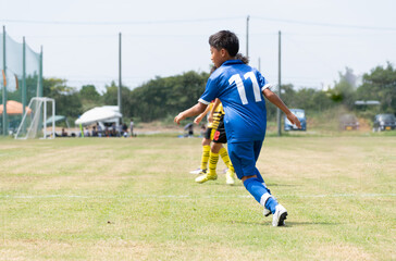 サッカーの試合をする小学生の男の子