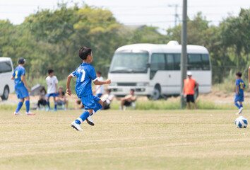 サッカーの試合をする小学生の男の子