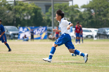 サッカーの試合をする小学生の男の子