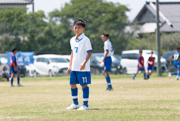 サッカーの試合をする小学生の男の子