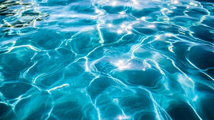 Obraz premium Clear, blue water surface with gentle ripples in a swimming pool, capturing the serene and tranquil effect of sunlight dancing on the water.
