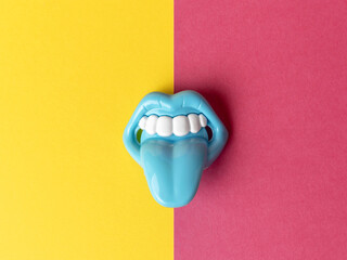 Blue Toy Mouth with Sticking Out Tongue on Yellow and Pink Split Background
