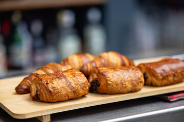 Fresh croissants on a cutting board close-up. French cuisine concept