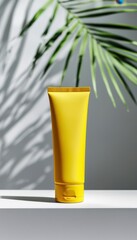 Vibrant yellow lotion tube, minimalist design, casting a playful shadow against a soft gray backdrop, accompanied by delicate palm fronds that evoke tropical vibes.