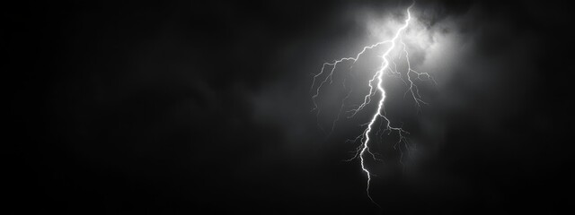  A black-and-white image of a lightning bolt piercing the night sky, illuminated by a radiant beacon shining through the clouds