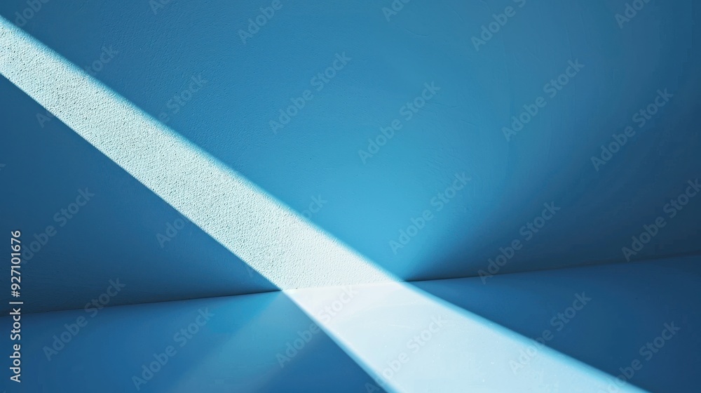 Aufkleber A narrow beam of light casts a diagonal line across a blue wall and floor, creating a geometric abstract. The light fades into the distance and is partially obscured by a shadow cast by an unseen obje