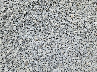 Close-up photo of a collection of gravel, ground stone grey background of many small stones
