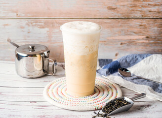 Iced Jasmine Green Milk Tea with sugar pot and spoon served in disposable glass isolated on table side view of hong kong tea