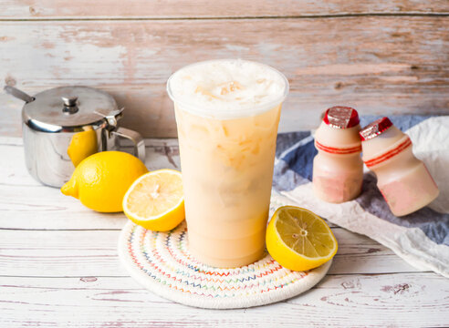 Iced Lemon Yakult Team with sugar pot and spoon served in disposable glass isolated on table side view of hong kong tea