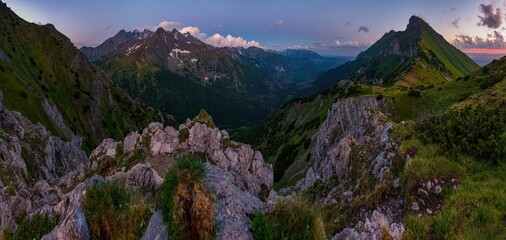 Obraz premium Evening twilight in Mountain landscape. View on Tatra Mountains National Park with remains of snow on peaks on colorful sunset. Belianske Tatry, Tatry Bielskie. Border of Poland and Slovakia.