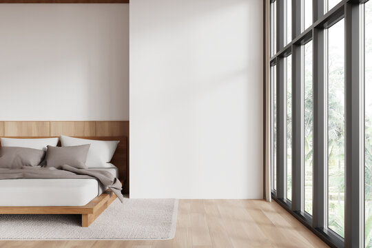 Modern hotel bedroom interior with bed near window, mock up wall
