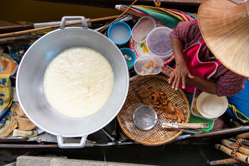 top view asian thai old woman Selling food in the central Thai traditional floating market that is very famous, causing many tourists to visit