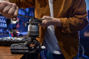 Mechanic disassembling and servicing bicycle internal-geared hub on vice