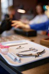 Sterile instruments for safe nail manicure on tray on foreground