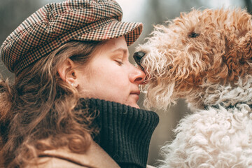 young woman holding dog fox terrier breed on her arm