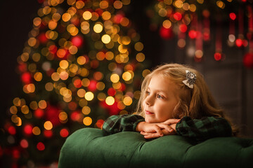 portrait of a beautiful girl on the background of a Christmas tree with lights