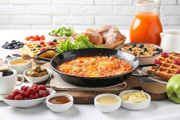 Different meals served for breakfast on white table