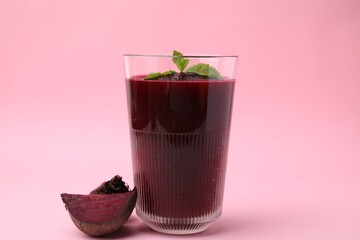 Fresh beetroot smoothie in glass and beet on pink table
