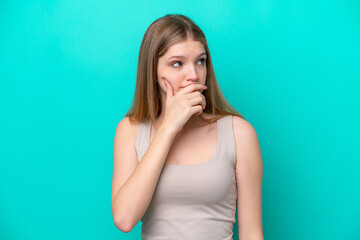 Teenager Russian girl isolated on blue background having doubts and with confuse face expression