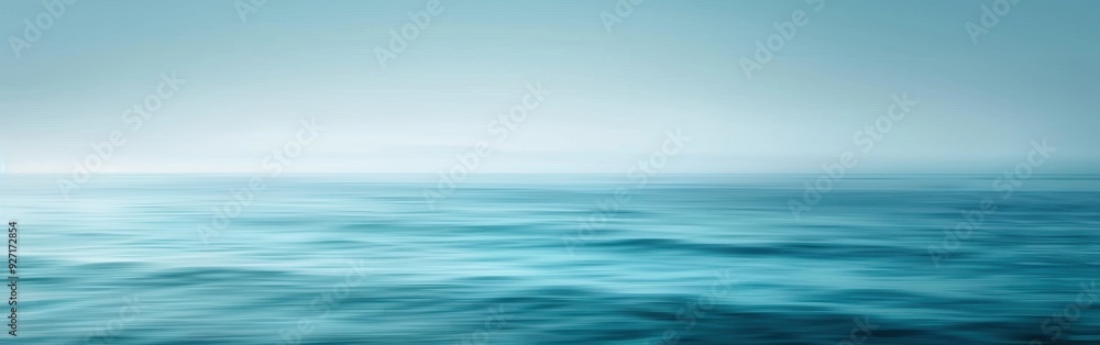 Poster a wide shot of the ocean on a foggy day. the water is a deep blue, with gentle waves rolling across 