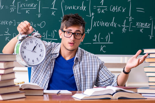 Young male student studying math at school