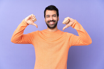 Caucasian handsome man over isolated purple background showing thumb down