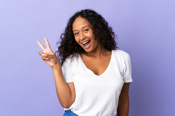 Teenager cuban girl isolated on purple background smiling and showing victory sign