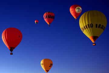Obraz premium Fireworks explode in the sky at night. Beach tree concept. Balloons of fire in the blue sky. Balloons with fireballs in the sky at lifestyle night.