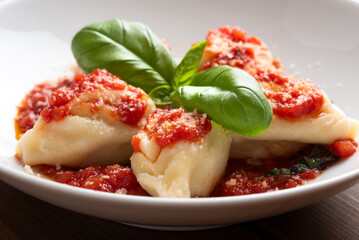 Primo piano di culurgionis ogliastrini, tradizionale pasta ripiena di patate, pecorino e menta, tipica della cucina sarda, cibo italiano, gastronomia europea 