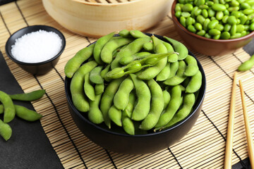 Raw green edamame soybeans and pods on grey table