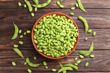 Raw green edamame soybeans and pods on wooden table, flat lay