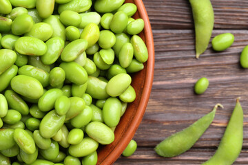 Raw green edamame soybeans and pods on wooden table, top view