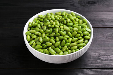 Raw green edamame soybeans on wooden table