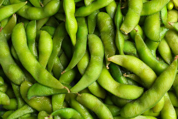 Fresh edamame pods as background, top view