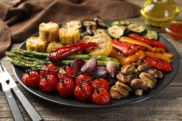 Delicious grilled vegetables served on wooden table, closeup