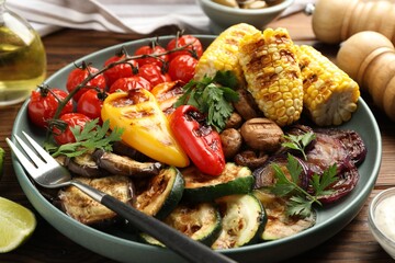 Delicious grilled vegetables served on wooden table, closeup