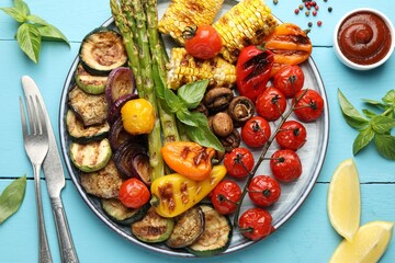 Delicious grilled vegetables served on light blue wooden table, flat lay