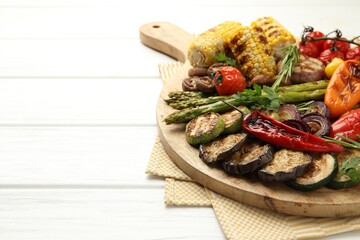 Delicious grilled vegetables on white wooden table, closeup. Space for text